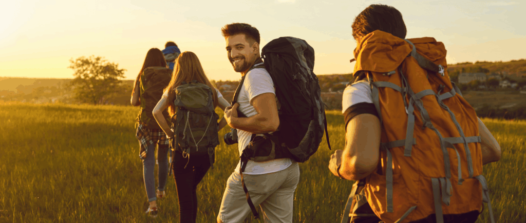 Four friends with hiking packs out in the wilderness